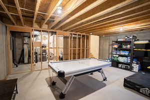 Game room featuring unfinished concrete flooring