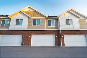 Townhome / multi-family property featuring board and batten siding and brick siding
