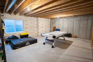Game room with unfinished concrete flooring