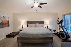 Bedroom featuring carpet, vaulted ceiling, baseboards, and ceiling fan