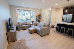 Living room with light wood-type flooring, recessed lighting, and baseboards
