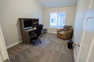 Home office featuring carpet flooring, baseboards, and lofted ceiling