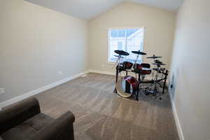 Playroom with carpet flooring, baseboards, and vaulted ceiling