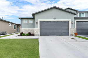 View of front of property, stone, stucco and attached 2 car garage.
