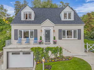 New england style home with a garage and roof with shingles