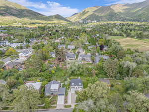 Aerial view of property and surrounding area featuring a mountainous background and nearby suburban area