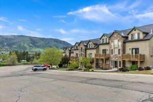 View of asphalt road with a residential view, a mountain view, and sidewalks