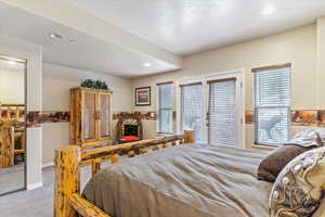 Bedroom featuring carpet floors, multiple windows, recessed lighting, and access to outside