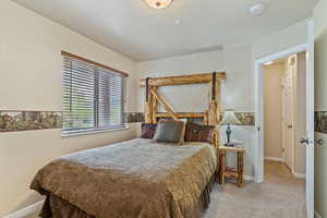 Bedroom featuring carpet and baseboards