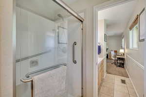 Bathroom featuring a stall shower, tile patterned flooring, and vanity