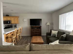 Living area with dark wood-style floors and baseboards