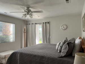 Bedroom featuring a ceiling fan and a textured ceiling