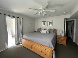 Carpeted bedroom with a ceiling fan and a textured ceiling