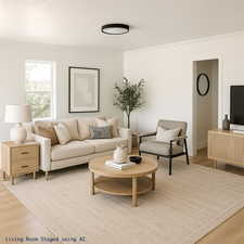 Living room featuring wood finished floors and crown molding