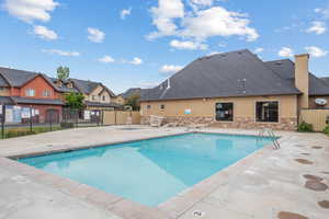 Community pool featuring a patio area and a residential view