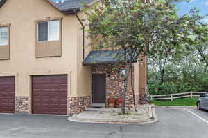 Townhome / multi-family property with stone siding and stucco siding