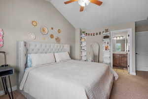 Bedroom featuring light colored carpet, lofted ceiling, connected bathroom, ceiling fan, and baseboards