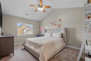 Bedroom with light carpet, vaulted ceiling, baseboards, and a ceiling fan