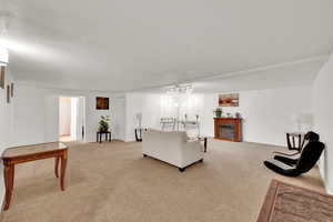 Living area with light colored carpet, baseboards, and a fireplace