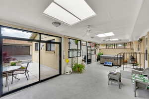 Sunroom / solarium featuring a hot tub, a skylight, and a ceiling fan