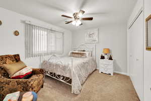 Bedroom featuring carpet floors, a closet, ceiling fan, and baseboards
