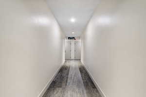 Corridor featuring dark wood finished floors and recessed lighting