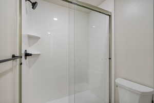 Full bathroom with a shower stall and toilet