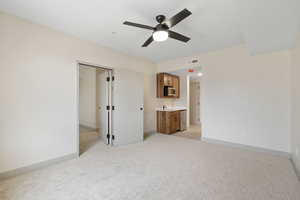 Unfurnished bedroom with light carpet and ceiling fan