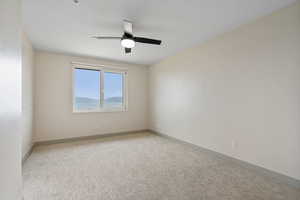 Unfurnished room with light colored carpet and ceiling fan