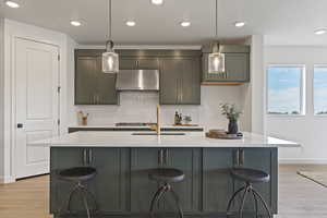 Kitchen featuring recessed lighting, a breakfast bar area, light wood-style floors, and tasteful backsplash