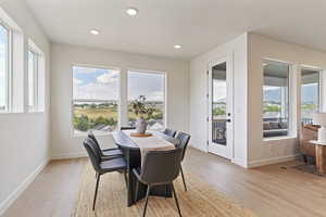 Dining room with healthy amount of natural light, light wood-type flooring, and recessed lighting