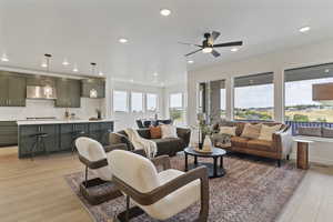Living room featuring light wood finished floors, recessed lighting, and a ceiling fan