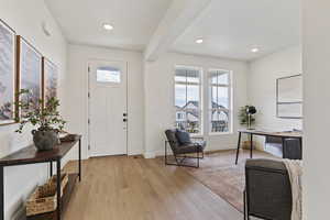 Foyer with plenty of natural light, beamed ceiling, light wood-style flooring, and recessed lighting