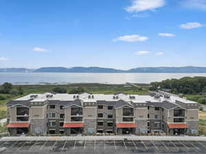 Drone / aerial view of a water and mountain view and apartment complex / building