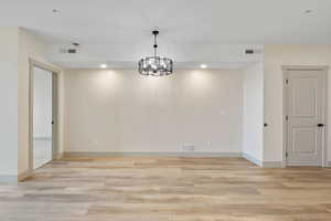 Unfurnished dining area featuring recessed lighting, light wood-type flooring, and a chandelier