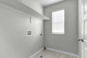 Laundry room featuring hookup for a washing machine, electric dryer hookup, healthy amount of natural light, and baseboards