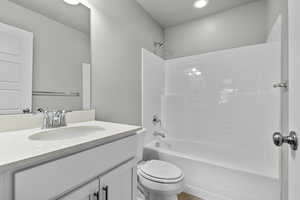 Full bathroom with toilet, bathing tub / shower combination, and vanity