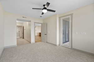 Unfurnished bedroom featuring light colored carpet, access to outside, and ceiling fan