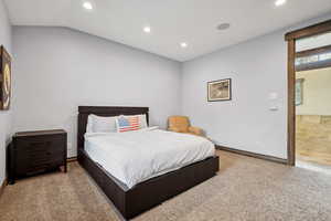 Carpeted bedroom with recessed lighting, lofted ceiling, and baseboards