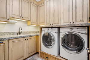 Laundry room with cabinet space and washer and clothes dryer