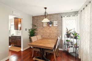 Dining area featuring dark wood-type flooring, baseboards, an accent wall, and a textured ceiling
