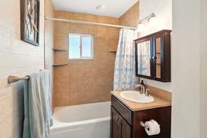 Bathroom featuring shower / bath combination with curtain and vanity
