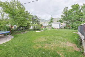 View of yard featuring a trampoline and a mountain view