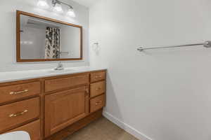 Bathroom with vanity, baseboards, toilet, and a shower with shower curtain