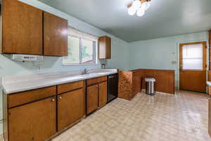 Kitchen with dishwasher, light countertops, plenty of natural light, and a sink