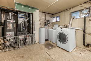 Washroom with washing machine and dryer, gas water heater, and heating unit