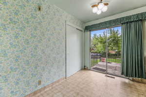 Spare room featuring wallpapered walls