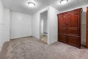 Unfurnished bedroom featuring light colored carpet