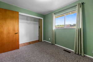 Unfurnished bedroom with carpet, a closet, and baseboards