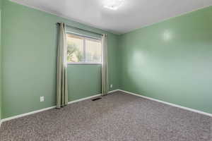 Carpeted spare room with baseboards